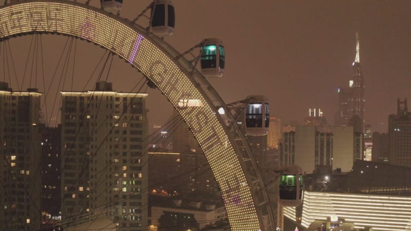 Aerial view of a Ferris wheel in Shanghai downtown at night, China.