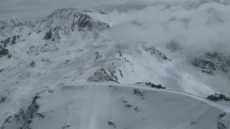 Aerial shot tilting up above Cime Caron ski slope in Val Thorens 