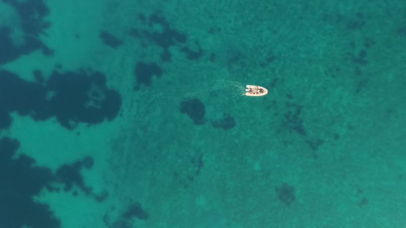 Aerial view of single speed boat floating over transparent water.