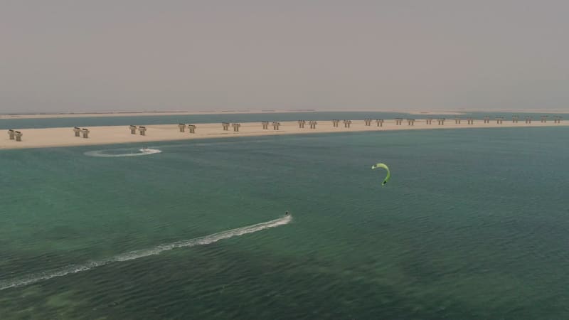 Aerial view of people practicing windsurfing at Jumeirah beach.