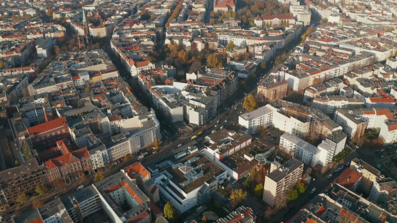 Typical Berlin Neighbourhood residential area in sunny daylight with view on Red rooftops and main Street, Aerial Wide Establishing Shot