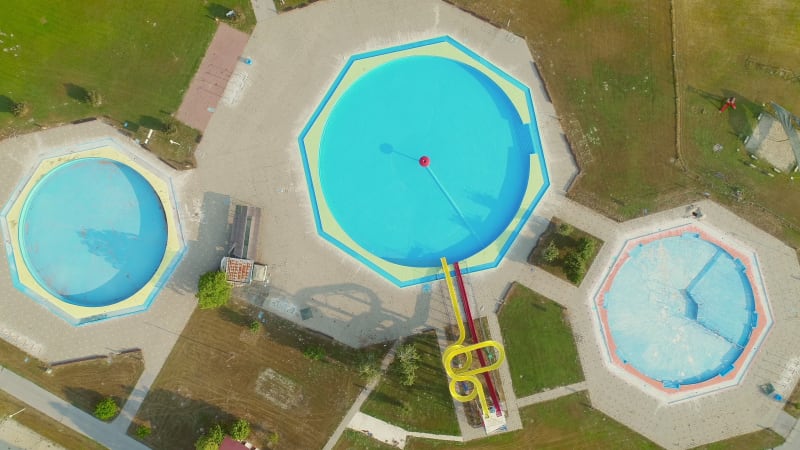 Aerial view of empty pools with slides in abandoned aqua park.