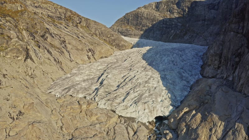 Spectacular fly over Nigardsbreen Glacier between mountain slopes in Norway.