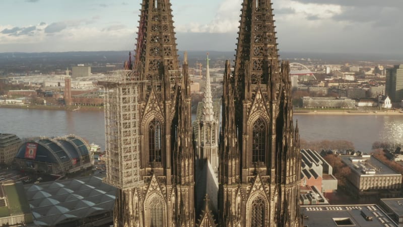 Aerial ascending footage of gothic historic religious landmark. Beautifully ornamented high towers of Cathedral Church of Saint Peter. Cologne, Germany