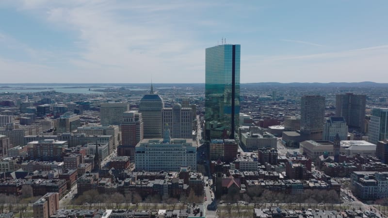 Forwards fly above urban borough. Glossy glass facade of John Hancock Tower reflecting surroundings. Boston, USA