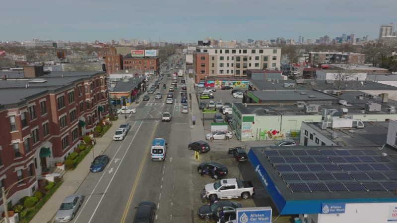 Busy streets in residential urban neighbourhood. Aerial view of vehicles driving on road and passing intersection. Boston, USA