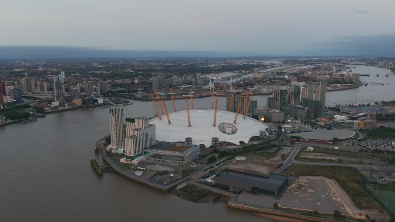 Aerial view of futuristic Millennium Dome. River Thames calmly flowing around The O2 entertaining district. London, UK