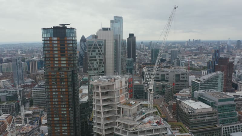 Aerial view of modern downtown skyscrapers in large city. Crane on construction site of new building. London, UK