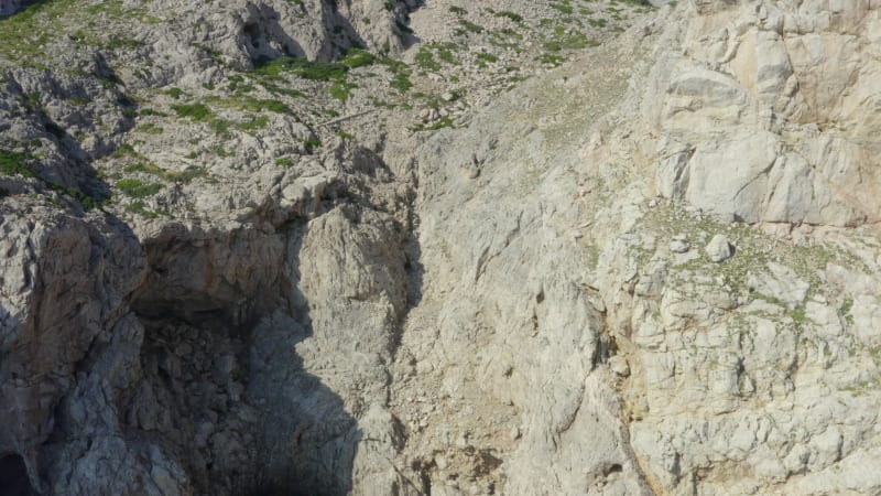 Guy Standing on Edge of Cliff with Blue Water Waves crMavic 2 prohing on Tropical Island Mallorca, Spain Vacation, Travel, Sunny, Waves