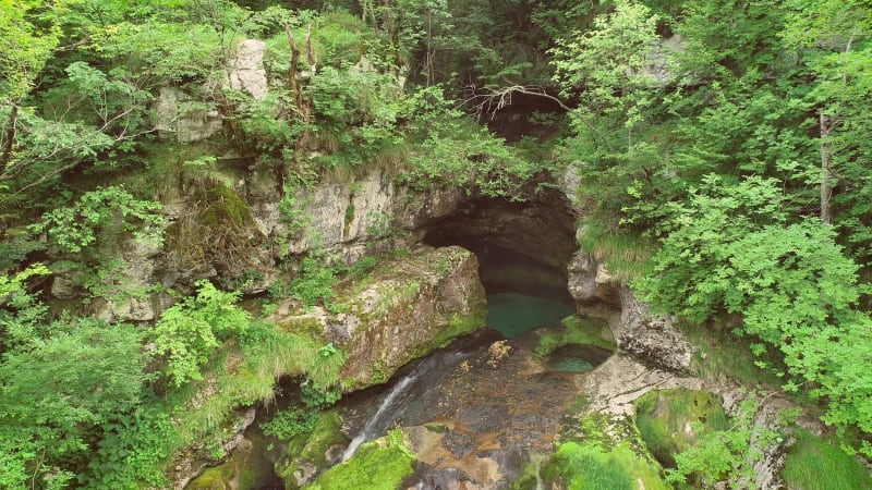 Aerial view of a waterfall surrounded by rocks and nature nearby.