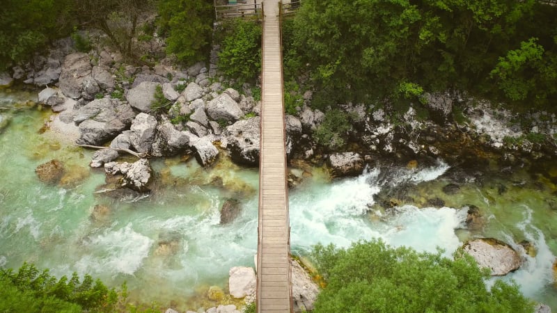 Aerial view of a wooden bridge with water going underneath.