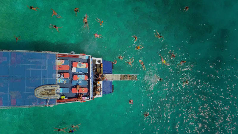 Aerial view of people in ferry diving on the sea, Ithaki island.