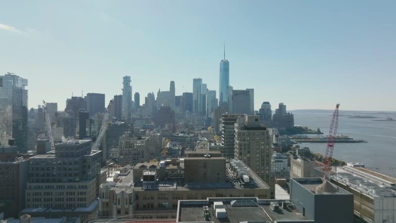 Forwards fly above tall buildings in city. Cityscape with modern office skyscrapers. Manhattan, New York City, USA