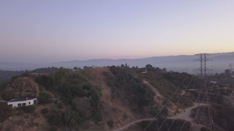 AERIAL: Over Hollywood Hills at Sunrise with view on hills and the valley in Los Angeles view