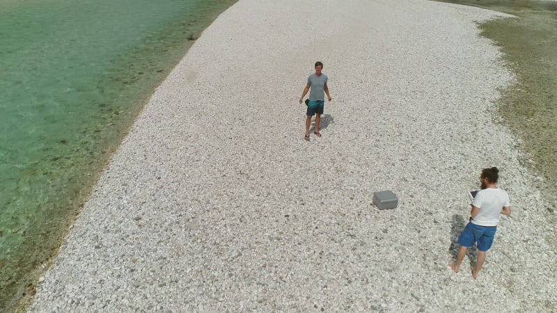 Aerial view of men starting to fly a drone.