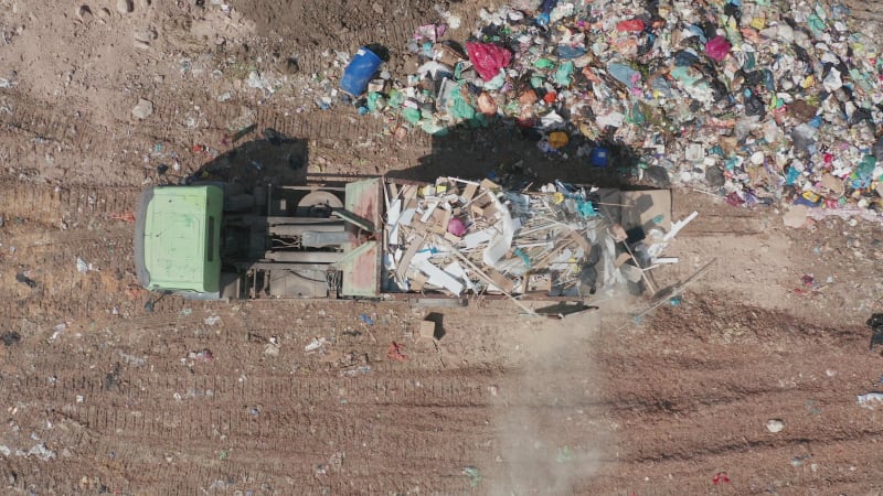 Loaded Garbage Truck discharge at a Municipal landfill, Top down aerial footage.