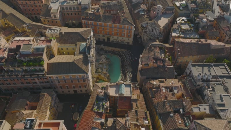 Aerial footage of famous tourist attraction, baroque Trevi Fountain. Sightseeing people in historic city centre. Rome, Italy