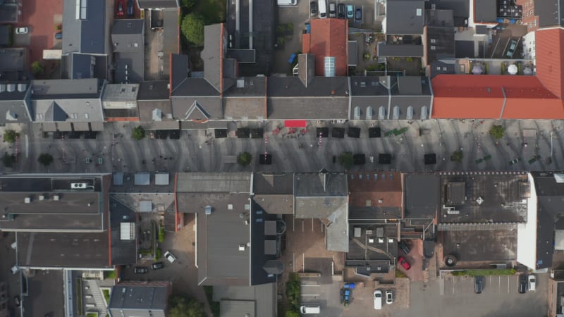 Top down view of Torvegade in Esbjerg, one of Denmark's longest pedestrian avenue. Overhead flight sliding with pedestrian strolling downtown and car parked parking lot