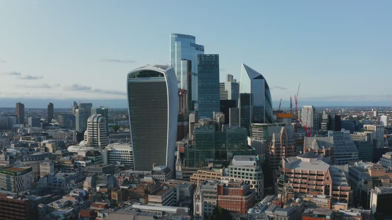 Slide and pan shot of iconic Walkie Talkie skyscraper and other futuristic tall modern buildings in City business hub. London, UK