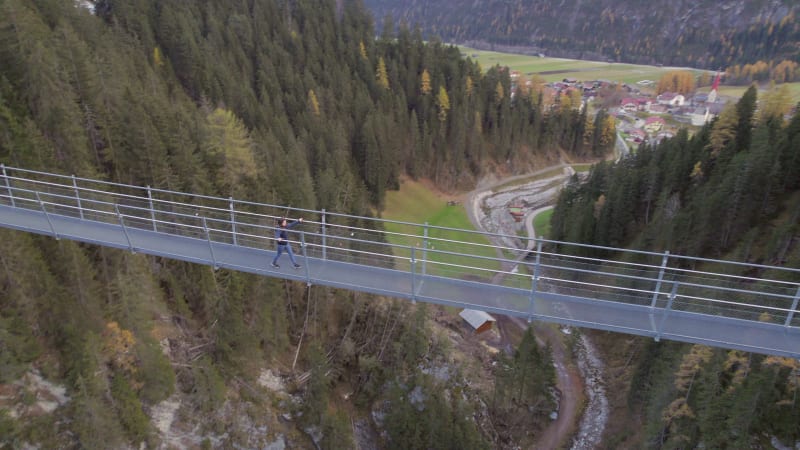 Girl Crossing a Footbridge Spanning a Ravine in Switzerland