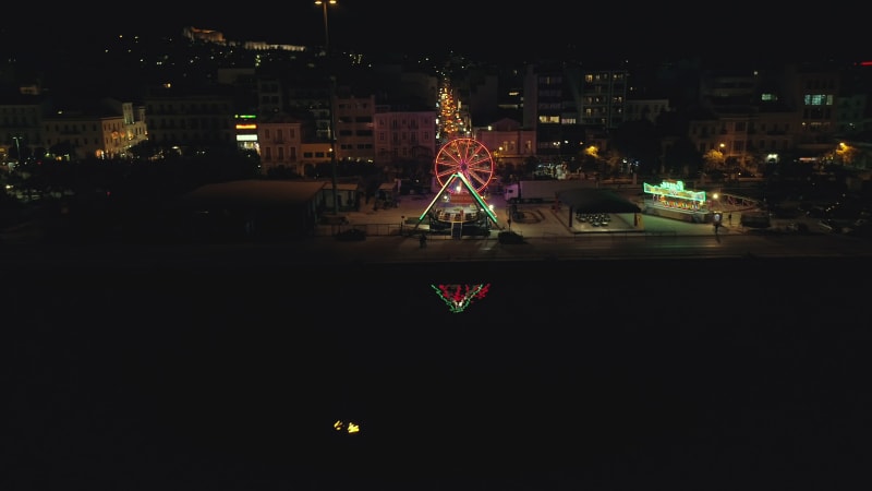 Aerial view of small amusement park with lights at night.