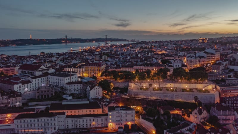 Aerial day to night hyperlapse of residential buildings and tourist landmarks in Lisbon city center