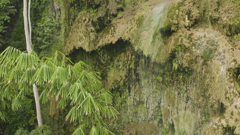 Descending aerial view of a waterfall and cliff edge in the Philippines