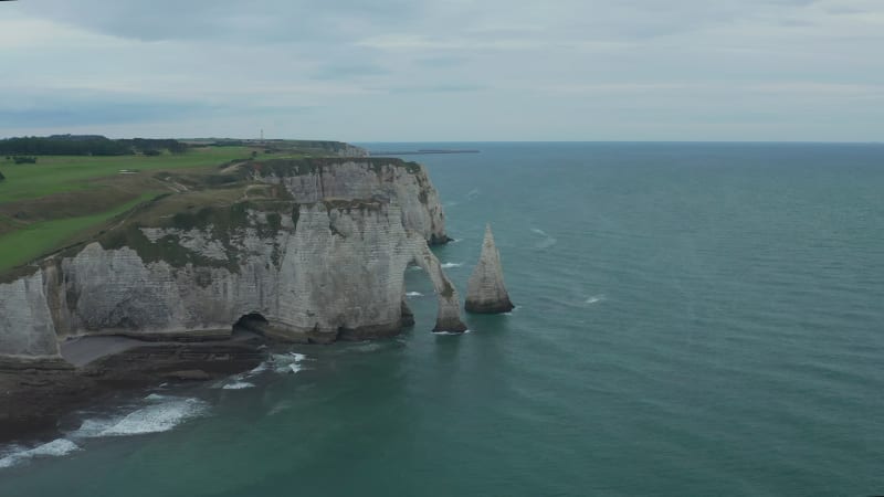 Slow Circling around Etretat Cliff Arches on Overcast Day with Dark Blue Ocean