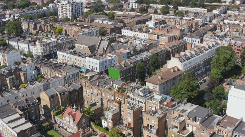 Fly above rows of townhouses. People living in urban neighbourhood. Aerial view of homes. London, UK