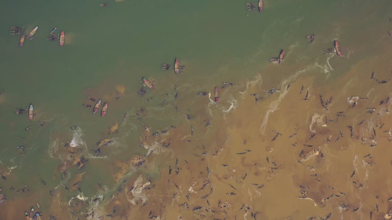 Aerial view of people using large fishing nets along Jadukata River, Bangladesh.