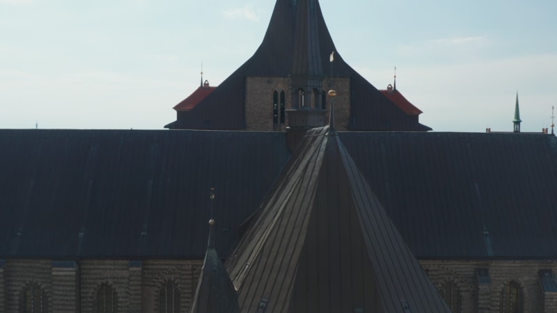 Forwards fly over roof of Saint Marys church. Brick gothic style building with turrets