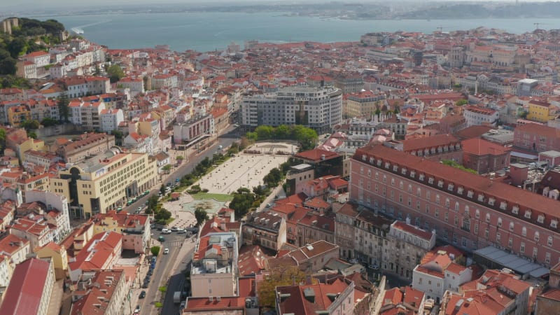 Aerial overhead top down birds eye view of people walking around large public square with water fountains in Lisbon city center