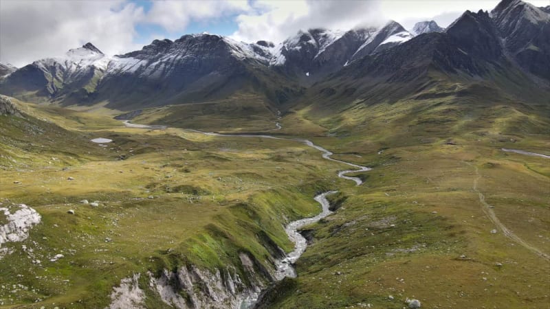 Aerial view of alpine plain with river gorge and mountains in Greina