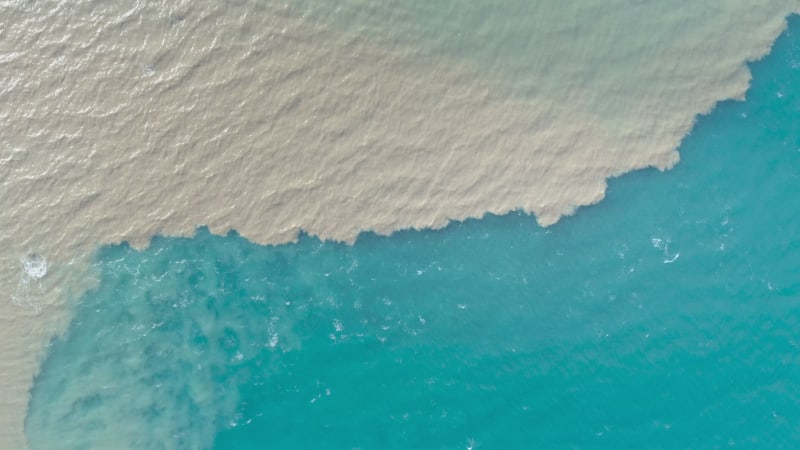 Aerial view of river and sea waters mixing in Rio.