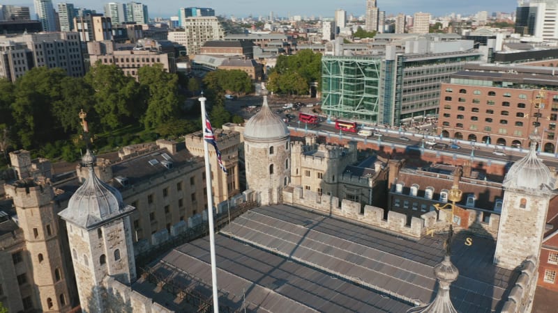 Tilt and pan shot of top of stone White Tower. Fly above historic landmark in Tower of London castle complex. London, UK