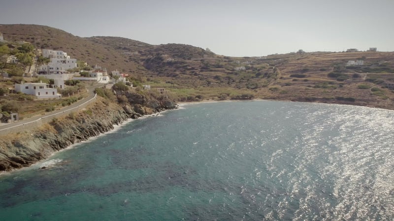 Aerial view of large white villas in front of beach at Ydroussa, Andros island.