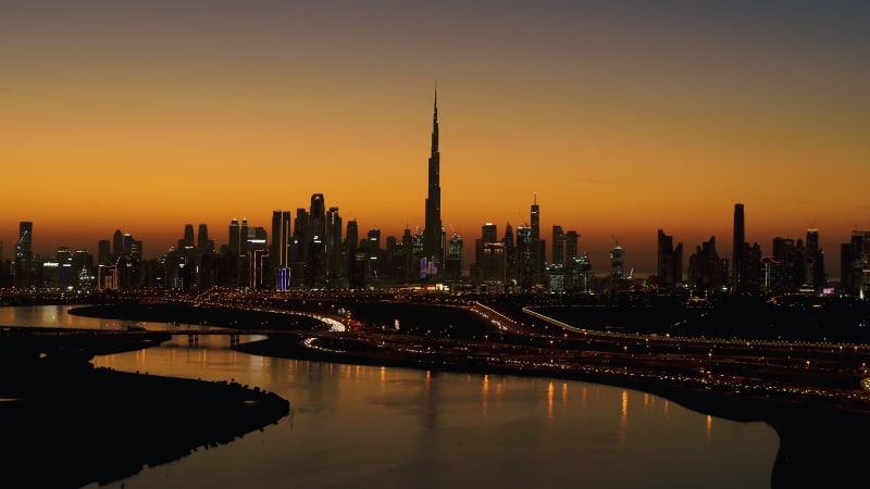 Aerial view of Dubai skyscrapers silhouettes at sunset.