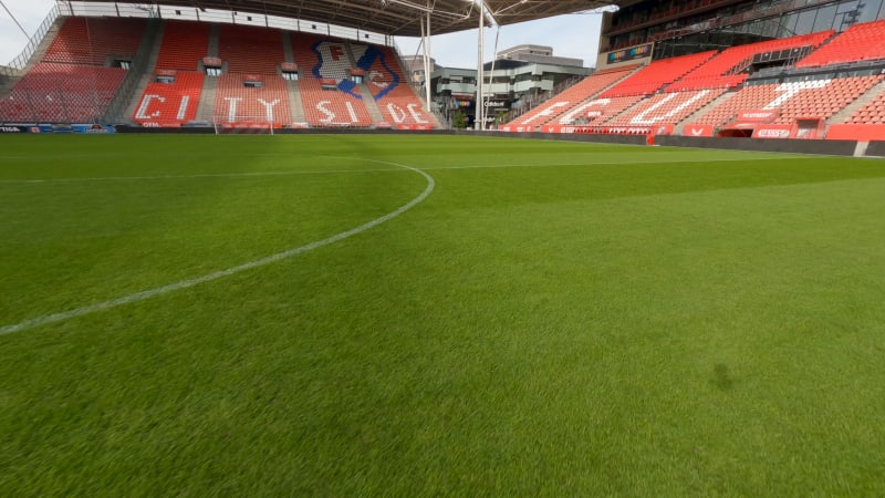 FPV drone shot over the football field of FC Utrecht, towards the goal. And scores into the goal