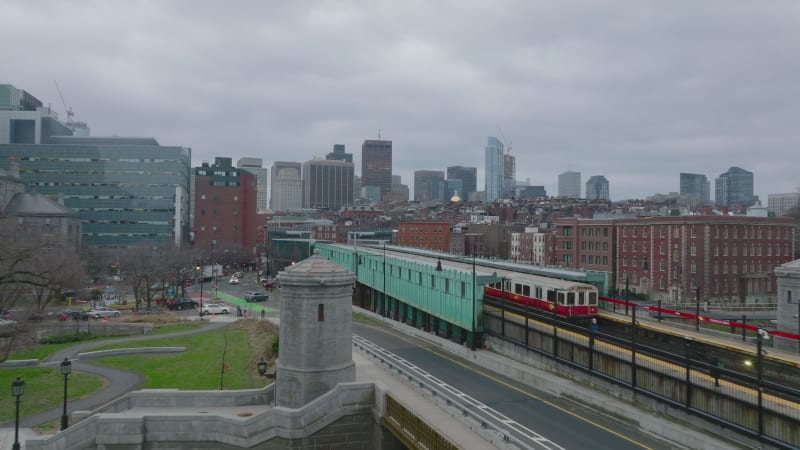 Forwards fly along train stop in city. Subway units driving on overground track on cloudy day. Boston, USA