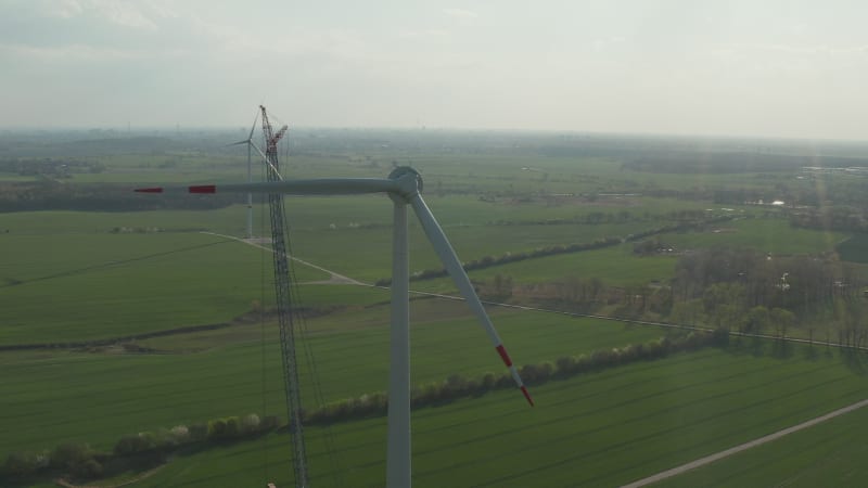 Wide View of Wind Turbine under construction being built on rich green agriculture field for renewable energy and sustainable Development