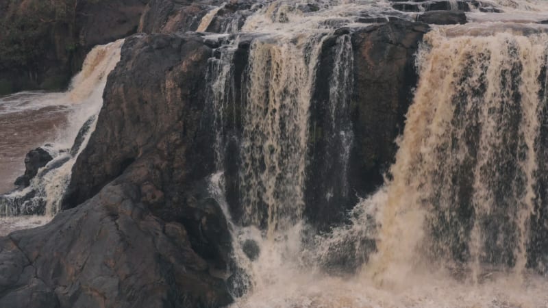 Fast flowing waterfall on dark rocky cliffs