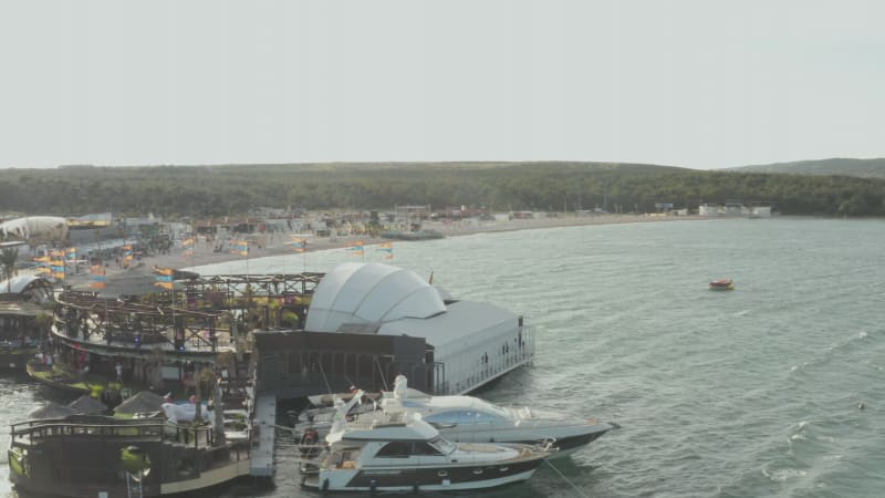 Beach Club build by the ocean with tropical waves and palm trees in Croatia, Aerial Wide Angle Shot