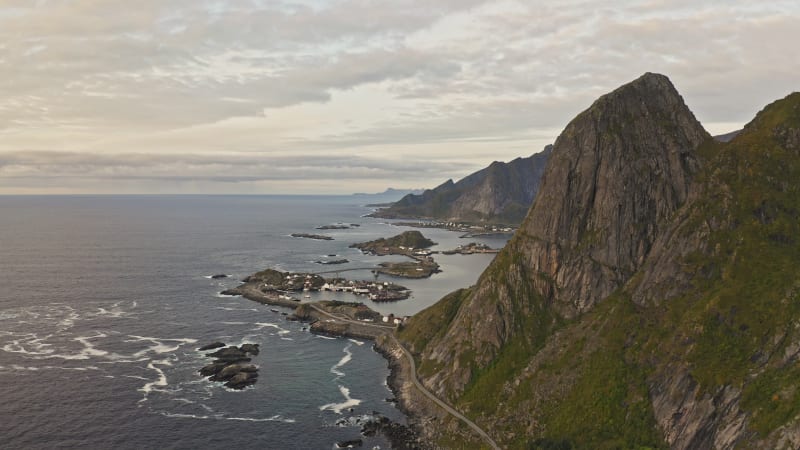 Coastal road along cliff towards seaside towns and tiny islands in Reine, Norway.