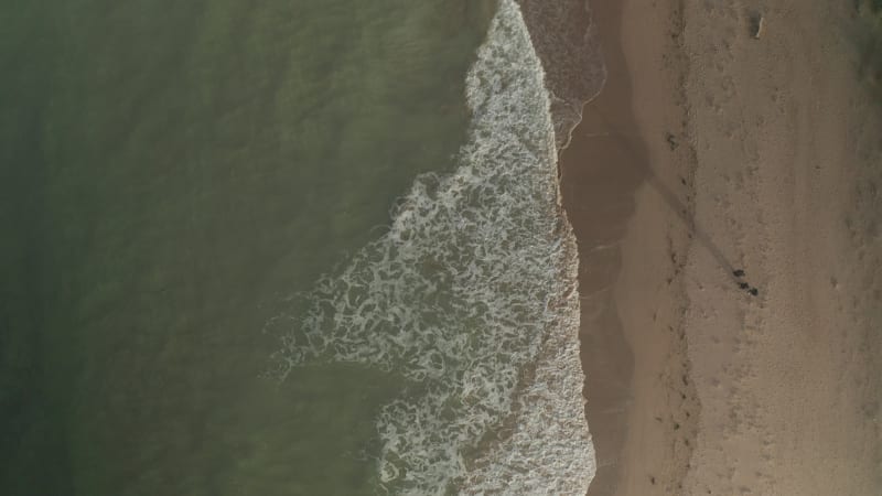 Aerial view of waves breaking on the beach in Cornwall, United Kingdom.