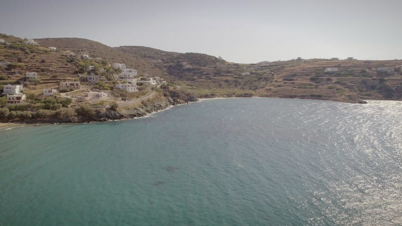 Aerial view of large white villas in front of beach at Ydroussa, Andros island.