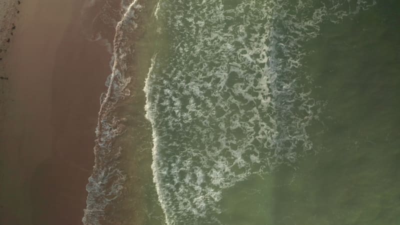 Aerial view of waves breaking on the beach in Cornwall, United Kingdom.