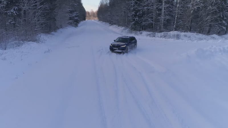Aerial view of a car driving in the snowy forest in Estonia