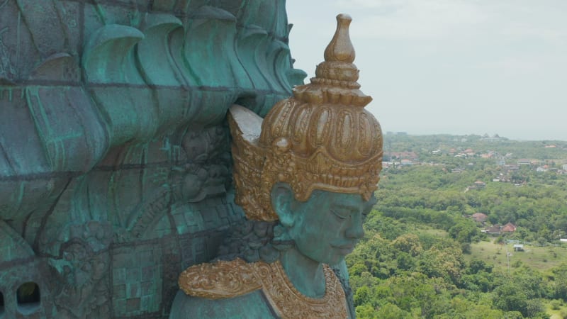 Garuda Wisnu Kencana statue in Bali, Indonesia. Close up aerial view of the face of Hindu deity Vishnu riding Garuda. Giant copper blue and green religious statue