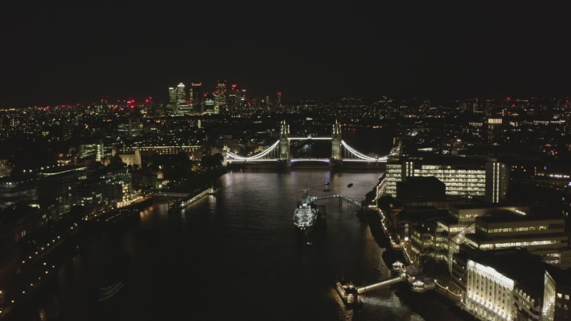 Aerial view of Tower bridge over Thames river at night. Famous landmark illuminated by bright light. London, UK