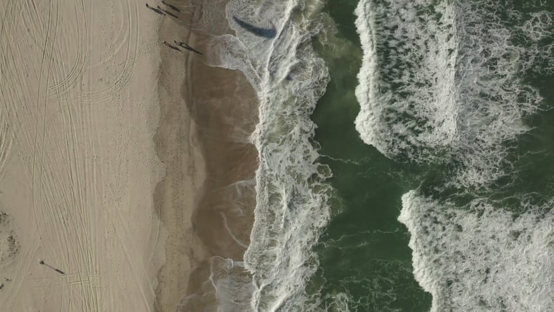 Top down view of people enjoying activities on a windy beach